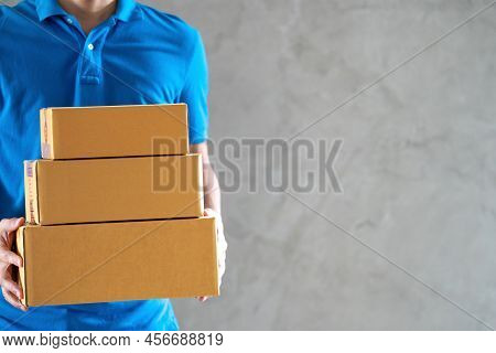 Delivery Service Courier Man Employee In Blue T-shirt Uniform Holding Empty Cardboard Boxes Or Parce