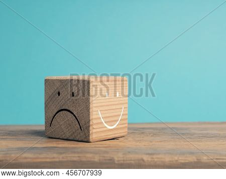 A Wooden Cube With Light And Dark Side, Once With Smiling Face And With Sad Face, There Is Always Th