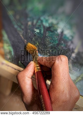 Artist Hand Holding Artist Brush To Paint On Canvas, Closeup For Background.