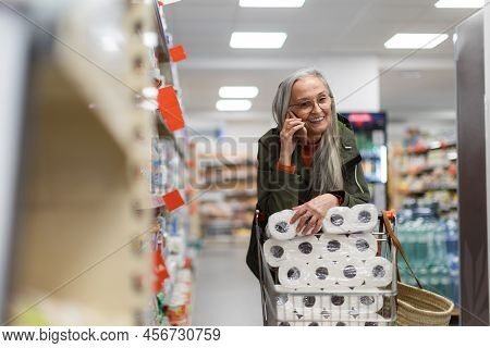 Senior Woman Buying Toliet Paper In Supermarket.