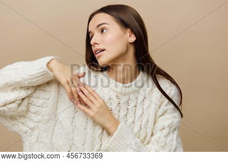 A Gentle Woman Stands On A Light Background In A White Sweater Pulls Her Head To The Side Lifting On