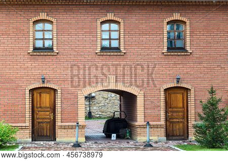 Brick Building With An Arch, Two Entrances And Three Windows.