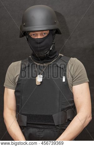 Muscular Military 45-50 Years Old In A Bulletproof Vest And Balaclava, Army Helmet On His Head, Blac