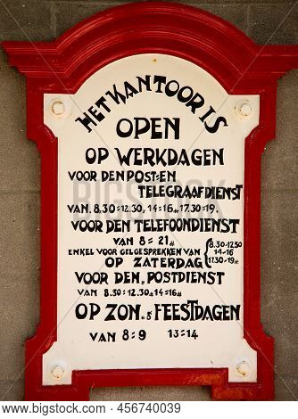 Enkhuizen, Netherlands, June 2022. Old Announcement Of The Opening Hours Of Dutch Post Office From T