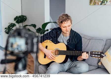 Young Man Playing Acoustic Guitar And Recording Music Video For His Social Networks. Amatuer Musicia