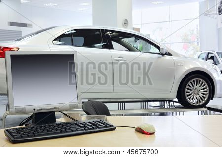 Computer steht auf Tisch und weißen Neuwagen im Amt des Shops, die Autos verkaufen.