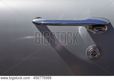 Closeup Details Of Chrome Door Handle Of A Grey Classic Car With Sun Reflection And A Shadow On The 
