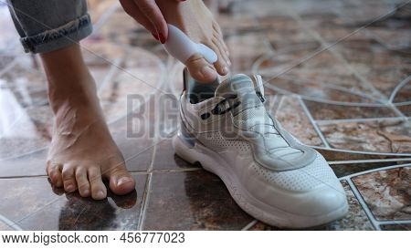 Close-up Of Woman Using Brace For Hallux Valgus And Putting On Sneaker. Podiatric Medicine And Defor