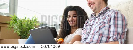 Portrait Of Friends Sitting On Carpet Floor Watching Movie On Laptop And Laughing. Latino American W