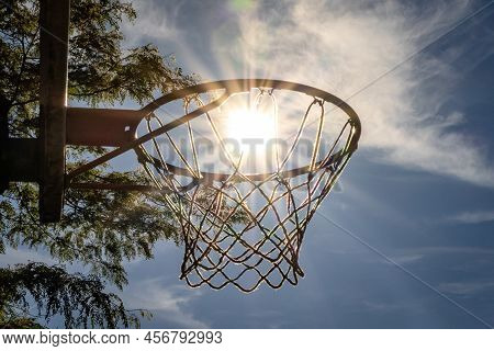 Shot Of The Sun Setting Into A Basketball Hoop
