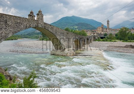 Bobbio, Italy , The Old Bridge (also Known As The Devil's Bridge) Over The Trebbia River, With The C