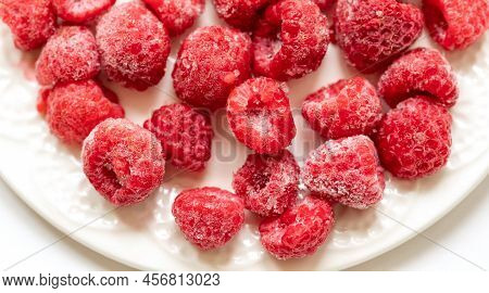 Frozen Raspberry On White Plate Close Up. Top View.