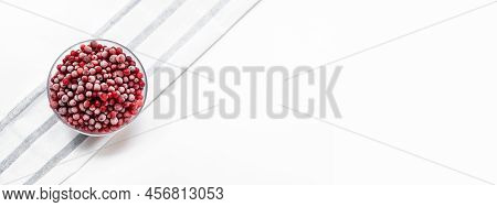 Frozen Cowberry In Glass Bowl On Striped Napkin On White. Banner. Top View. Copy Space.