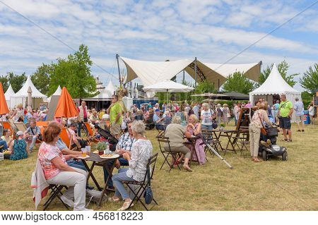 Magdeburg, Germany - June 11, 2022: People Sit At Tables In An Open-air Cafe