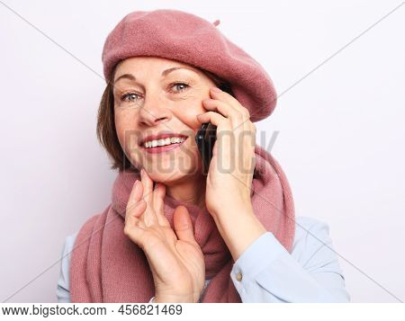 Elderly Woman Wearing Pink Scarf And Hat With Smartphone