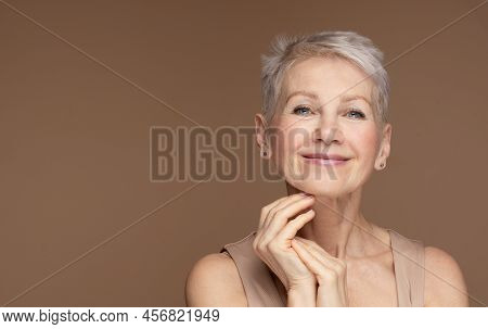 Beauty Portrait Of Mature Woman Smiling With Hand On Face.