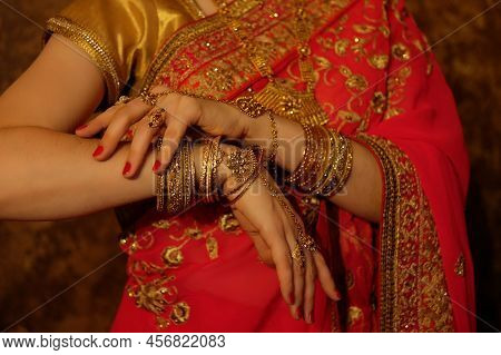Hands Of An Indian Bride Close-up. Lots Of Jewelry, Traditional Sari.