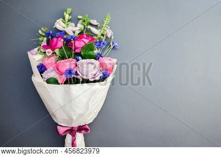 Fresh Bouquet Of Roses Foxgloves Bachelor Buttons Flowers Wrapped In Paper And Arranged On Backgroun