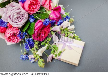 Close Up Of Summer Bouquet Of Roses Foxgloves Bachelor Buttons Flowers Arranged On Grey Background W
