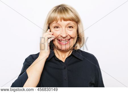 Attractive Elderly Woman With Smartphone Over White Backgrou