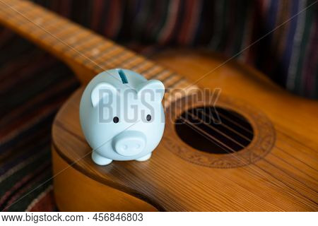 Music And Saving Concept With Pig Piggy Bank On The Guitar