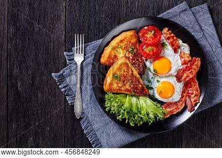 Irish Breakfast Of Fried Eggs, Bacon Slices, Fried Potato Farls, Grilled Tomatoes And Fresh Lettuce 