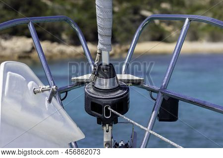 Sailboat Bow With Sail System And Anchor To The View And Unfocused Beach In The Background