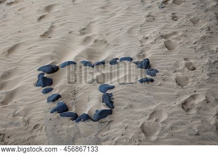 On A Beach A Heart Was Formed From Individual Stones. Stone Heart On The Beach.