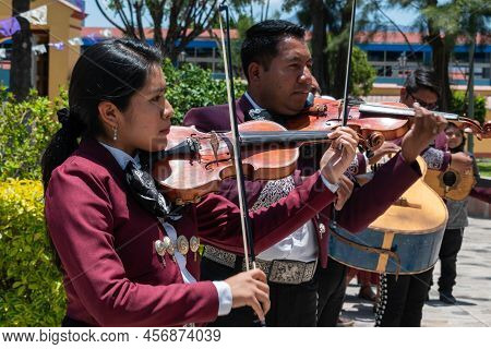 Tlacolula, Oaxaca, Mexico- May 23, 2022: Members Of Mariachi Playing Violin Outside Of Parroquia San