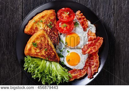 Irish Breakfast Of Fried Eggs, Bacon Slices, Fried Potato Farls, Grilled Tomatoes And Fresh Lettuce 