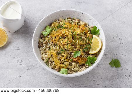 Traditional Middle Eastern Dish, Mujadara Of Lentils, Rice And Fried Onions With Lemon And Herbs On 