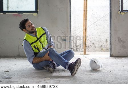 Young Caucasian Man In Safety Vest Gripped His Knee And Screams In Pain. Due To Injuries At The Cons