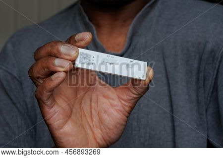 Person Of African Ethnicity Holding A Single Positive Covid-19 Rapid Home