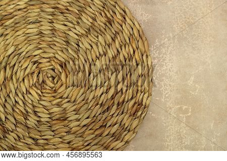 Dried Grass Straw Circular Woven Matt On Vintage Worn Background