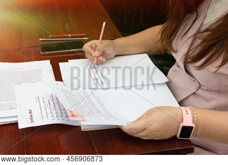 Woman Working On Paperwork On Table For Proofreading Service