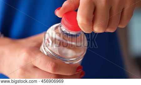 Female Hands Opening Plastic Water Bottle Closeup. Drinking Regimen Concept
