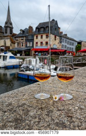Tasting Of Apple Calvados Drink In Old Honfleur Harbour With Boats And Old Houses On Background, Nor