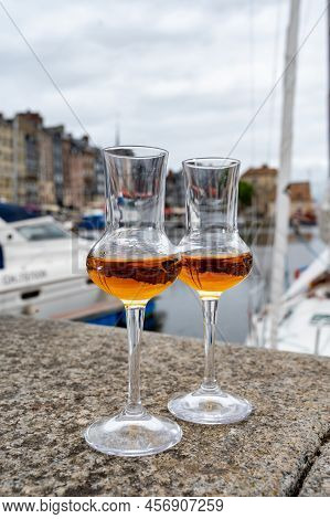Tasting Of Apple Calvados Drink In Old Honfleur Harbour With Boats And Old Houses On Background, Nor