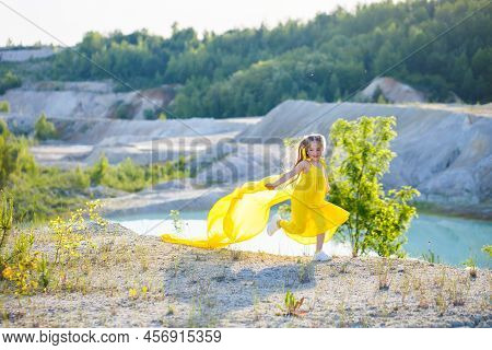 Ukrainian Girl 7 Years Old, She Is A Patriot Of Ukraine, Dressed In A Yellow Dress Against A Blue Sk