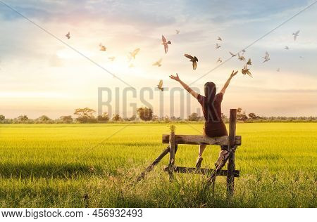 Woman Praying And Free Bird Enjoying Nature On Sunset Background, Hope Concept