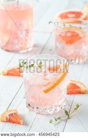 Glasses Of Refreshing Grapefruit Spritzer On A Light Wooden Table.