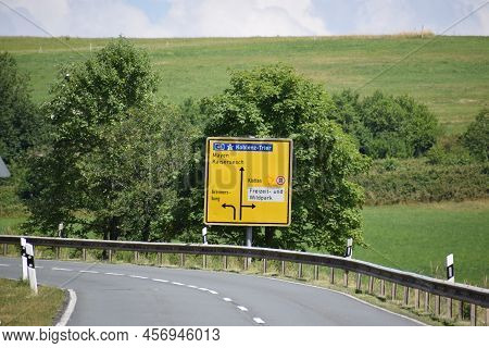 Country Road With A Traffic Sign To Several Villages And The Highway