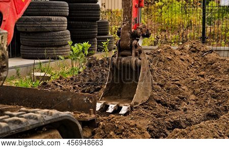 Basic (universal) Excavator Bucket With Three Sharp Steel Teeth. Digging A Trench. Visible Elements 