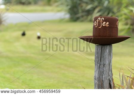 Okarito New Zealand - April 30 2022; Rusty Iron Cup, And Saucer On Top With Sign Coffee Rusty Iron C