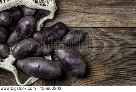 Raw Sweet Potatoes On Wooden Background, Organic Purple Sweet Potato. Raw Sweet Potatoes Or Batatas.