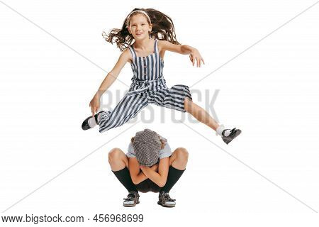 Happy School Age Kids Wearing Retro Clothes Playing Leapfrog Isolated Over White Background. Concept