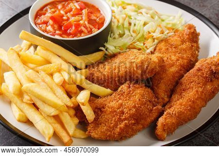 Serbian Fried Chicken With French Fries, Cabbage Salad And Hot Sauce Close Up In The Plate On The Ta