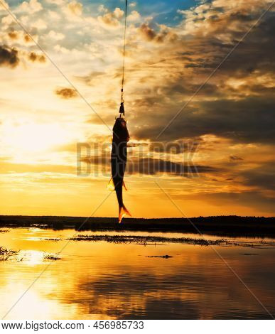 Fishing At Sunset. Catching Predatory Fish On Spinning. Sunset Colors On The Water Surface, Sunny Pa