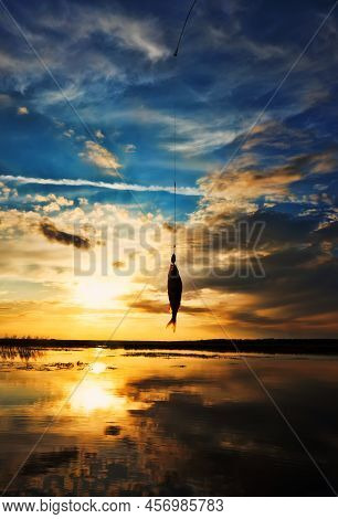 Fishing At Sunset. Catching Predatory Fish On Spinning. Sunset Colors On The Water Surface, Sunny Pa