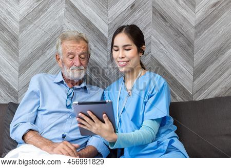 Nurse Helping Patient For Using Tablet. Caretaker And Senior Man Using Tablet Pc At Nursing Home